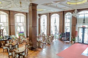 a large room with tables and chairs and windows at LCS Hotel & Apartment in Phnom Penh