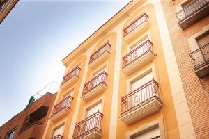 um edifício amarelo com varandas ao lado em Mesones parking gratis climatizado em Jaén