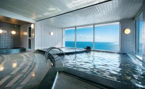a bathroom with a swimming pool with a view of the ocean at The Gran Resort Elegante Awajishima in Awaji
