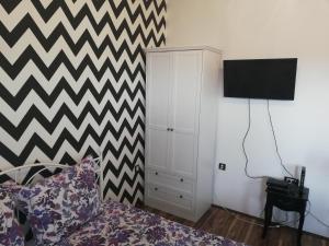 um quarto com uma cama e uma televisão na parede em Urban Chic em Novi Sad