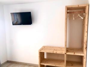 a tv on a wall next to a wooden shelf at Gradlhof in Postbauer-Heng