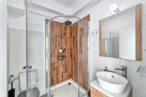 a bathroom with a glass shower and a sink at Cloud Studio in Sibiu +5 photos