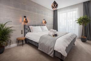 ein Schlafzimmer mit einem großen Bett und Pflanzen in der Unterkunft Kanopian Penthouse Brasov in Braşov