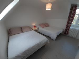 1 dormitorio con 2 camas, lámpara y ventana en Maison village Kermorvan, 300m plage, 5-6 pers., en Quiberon