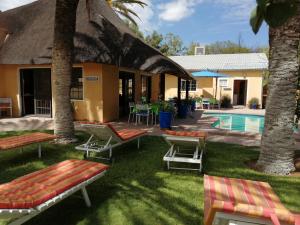 a resort with a pool and some chairs and a building at Capbon Guesthouse in Windhoek