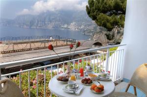 un tavolo con cibo su un balcone con vista di Hotel Le Fioriere a Praiano