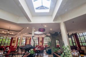 a restaurant with tables and chairs and a skylight at African Tulip in Arusha