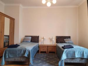 1 dormitorio con 2 camas y espejo en B&B MILES APARTMENT en Katowice