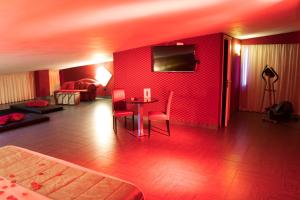 a living room with a table and a red wall at Hotel Masaniello Luxury in Casoria