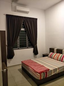 a bedroom with a bed and a window at NeoHomeStay Gapam Lestari in Malacca