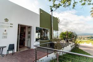 ein Gebäude mit einem Balkon mit einem Tisch und Stühlen in der Unterkunft Val Du Charron Wine & Leisure Estate in Wellington