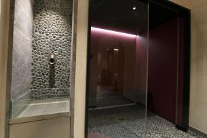 szklanymi drzwiami prowadzącymi do łazienki z korytarzem w obiekcie Hotel Fonte Dei Veli w mieście Panchia