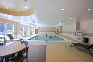 a swimming pool in a room with a table and chairs at Holiday Inn Express & Suites Atlanta NE- Duluth, an IHG Hotel in Duluth