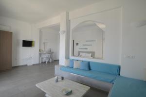 a room with a white couch and a blue wall at The Last Sunbeam - Adults Only in Fira