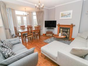 a living room with two couches and a dining room at Elmbank in Looe
