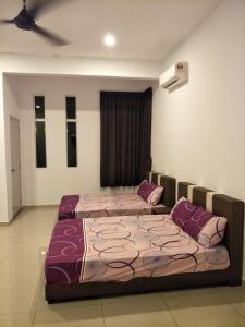two beds sitting in a room with at NeoHomeStay Gapam Lestari in Malacca
