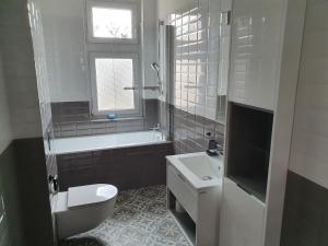 łazienka z toaletą, umywalką i wanną w obiekcie B&B MILES APARTMENT w mieście Katowice