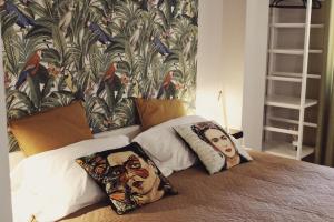 a bed with two pillows on it with a wallpaper at ApartHotel Le Sirene - FRIDA in Tivoli