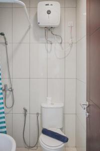 a small bathroom with a toilet and a shower at Cozy 1BR Asatti Apartment By Travelio in Tangerang