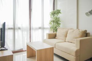 a living room with a couch and a table at Cozy 1BR Asatti Apartment By Travelio in Tangerang