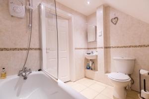 a bathroom with a tub and a toilet and a shower at 2 Bedroom Penthouse, Clockhouse, Hoddessdon in Hoddesdon
