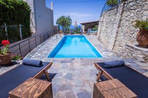 una piscina in un cortile con due panchine di Villa Ventus, 40sqm private pool & hot tub! a Roussospítion