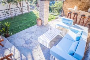 un patio con 2 sedie blu e un tavolo di Villa Ventus, 40sqm private pool & hot tub! a Roussospítion