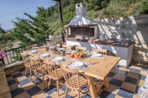 un tavolo e sedie su un patio con camino di Villa Ventus, 40sqm private pool & hot tub! a Roussospítion