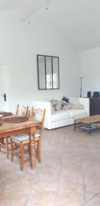 uma sala de estar com uma mesa e um sofá branco em Finca Maroma em Cómpeta
