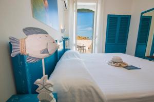 una camera da letto con un letto decorato con motivi di pesce di Hotel La Roccia a Castro di Lecce