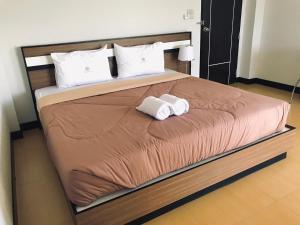 a bed with two rolled up towels on it at Smile Place (สมายเพลส) in Chom Thong