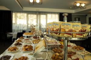 
a table filled with lots of different types of doughnuts at Best Western JFK Hotel in Naples

