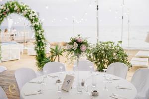 a white table with white chairs and flowers on it at Island Boutique Hotel in Larnaca