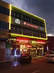 a building with a car parked in front of it at J Boutique Hotel 新张优惠 in Muar