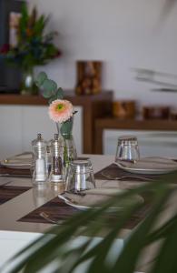 a table with plates and glasses and a vase with a flower at Island Boutique Hotel in Larnaca