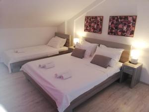 2 letti in una piccola camera con 2 lampade di Apartments House 91 a Kotor (Cattaro)