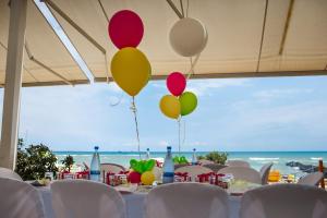 a table with balloons on it with the beach in the background at Island Boutique Hotel in Larnaca