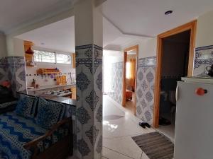 a kitchen and a living room with a refrigerator at Riad Sidi Rahal Beach in Sidi Rahal