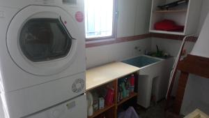 kuchnia z pralką obok zlewu w obiekcie Maribella chambres à louer w mieście Badolatosa