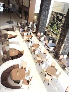 einen Blick über ein Restaurant mit Tischen und Stühlen in der Unterkunft Ascent Premiere Hotel and Convention in Malang