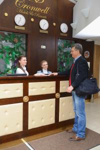 a man standing at a counter with two women at Cronwell Inn Stremyannaya in Saint Petersburg