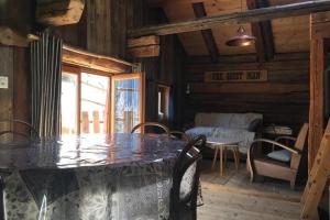ein Esszimmer mit einem Tisch und Stühlen in einer Hütte in der Unterkunft La cabane de l'homme tranquille in Le Trétien