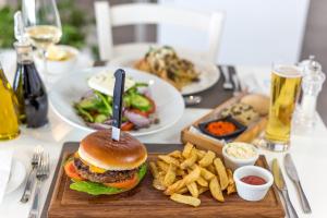 a hamburger and french fries on a table at Island Boutique Hotel in Larnaca