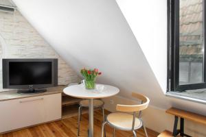 a small white table with two chairs and a tv at Elite Apartments Rooftop with a View of the Old Town in Gdańsk