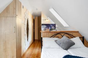 een slaapkamer met een bed met een houten hoofdeinde bij Elite Apartments Rooftop with a View of the Old Town in Gdańsk