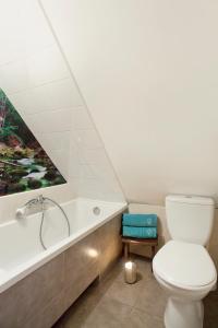 a bathroom with a toilet and a bath tub at Elite Apartments Rooftop with a View of the Old Town in Gdańsk