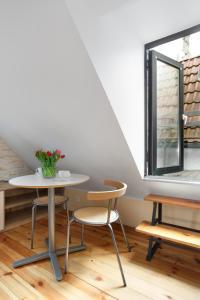 a table and chairs in a room with a window at Elite Apartments Rooftop with a View of the Old Town in Gdańsk