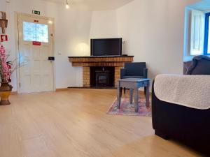 a living room with a tv and a chair and a fireplace at A Alma Portuguesa in Fátima
