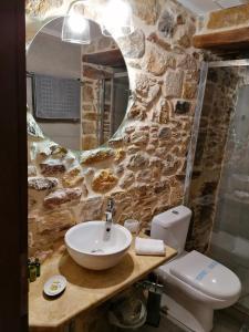 a stone bathroom with a sink and a toilet at Castro Rooms Chios in Chios