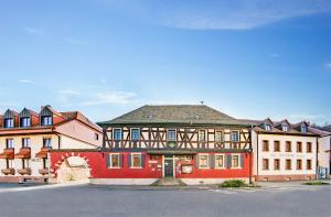 un gran edificio rojo con techo negro en Hotel-Restaurant Zur Kanne, en Schifferstadt